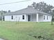 Rear view of a house with covered patio and grassy yard at 15467 Maynard Ave, Port Charlotte, FL 33953