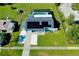 Aerial view of a house with solar panels, pool, and driveway at 4625 Pan American Blvd, North Port, FL 34287