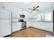 Modern kitchen featuring white cabinets, granite countertops, stainless steel appliances, and wood flooring at 4625 Pan American Blvd, North Port, FL 34287