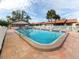 Community pool with patio furniture and covered seating area at 885 Country Club Cir # 61, Venice, FL 34293