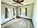 Bright bedroom with light grey walls, wood-look flooring, and two windows at 129 Gulf Ave, Nokomis, FL 34275