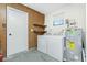 Utility/laundry room with washer, dryer, water heater, shelves and wood-look paneling at 1439 Strada D Argento, Venice, FL 34292