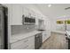 White shaker cabinets, marble countertops, herringbone backsplash, stainless steel appliances at 606 Marcus St # 26, Venice, FL 34285