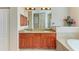 Double vanity with granite countertops and wood cabinets at 620 Lakescene Dr, Venice, FL 34293