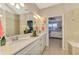 Elegant bathroom with double vanity, large mirror, and a view of the bedroom at 13097 Rinella St, Venice, FL 34293