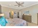 Spacious bedroom with a queen-size bed, ceiling fan, and walk-in closet at 13097 Rinella St, Venice, FL 34293