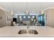 Kitchen features a large island with seating, a stainless steel sink, and a view to the living area at 13097 Rinella St, Venice, FL 34293