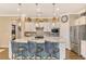 Modern kitchen with white cabinets, quartz countertops, and island with seating at 13097 Rinella St, Venice, FL 34293
