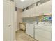 Laundry room with white cabinets, mosaic backsplash, and washer/dryer at 13097 Rinella St, Venice, FL 34293
