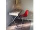 Small writing desk with a red chair and gold lamp on an area rug at 4137 Maceachen Blvd, Sarasota, FL 34233