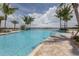 Inviting resort-style pool with palm trees and a lake view at 254 Toscavilla Blvd, Nokomis, FL 34275