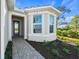 Inviting front entry with a paved walkway and well-manicured landscaping at 26056 Seastone Dr, Englewood, FL 34223