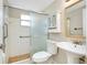 Bright bathroom with a pedestal sink, toilet, and shower at 1323 Karen Dr, Venice, FL 34285