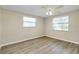 Bright bedroom with two windows and wood-look flooring at 1323 Karen Dr, Venice, FL 34285