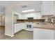 Galley kitchen with white cabinets and granite countertops at 1323 Karen Dr, Venice, FL 34285