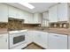 Bright kitchen with white cabinets, tile backsplash, and modern appliances at 1323 Karen Dr, Venice, FL 34285