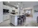 Modern kitchen with white cabinets, granite countertops, and an island with seating at 19764 Ortona St, Venice, FL 34293