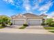 Tan two-car garage home with tile roof and landscaping at 21621 Winter Park Ct, Venice, FL 34293