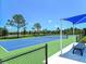 Well-maintained tennis court with seating area at 21621 Winter Park Ct, Venice, FL 34293