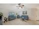 Bright living room features comfy seating, a large TV, and ceiling fan at 23442 Moreland Ave, Port Charlotte, FL 33954