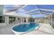 Relaxing kidney-shaped pool with screened enclosure and patio access at 23442 Moreland Ave, Port Charlotte, FL 33954