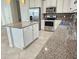 Granite countertop island, stainless steel appliances, white cabinets at 2501 Sherman Oak Dr, North Port, FL 34289