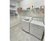 Laundry room with washer, dryer, and ample storage shelves at 2501 Sherman Oak Dr, North Port, FL 34289