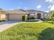 Single-story home with tile roof and lush lawn at 614 May Apple Way, Venice, FL 34293