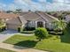 Single-story home with tile roof, two-car garage, and landscaped lawn at 614 May Apple Way, Venice, FL 34293