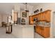 Open kitchen with granite countertops, breakfast bar, and wood cabinets at 614 May Apple Way, Venice, FL 34293