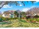 Inviting single-story home featuring lush landscaping, a manicured lawn, and a tile roof at 6930 Treymore Ct, Sarasota, FL 34243