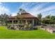 Exterior of the community clubhouse lobby with rock features and elegant landscaping at 6930 Treymore Ct, Sarasota, FL 34243