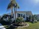 Well-maintained home exterior surrounded by lush landscaping, grass and palm trees at 789 N Green Cir, Venice, FL 34285