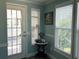 Hallway with natural light from two windows, and small table against blue wall at 789 N Green Cir, Venice, FL 34285