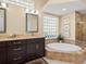 Elegant bathroom with double vanity, soaking tub, and glass shower at 824 Blue Crane Dr, Venice, FL 34285