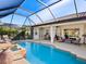 Inviting pool and spa with screened enclosure and lounge chairs at 824 Blue Crane Dr, Venice, FL 34285