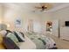 Main bedroom with plush carpet, ceiling fan, and access to the bathroom at 10788 Trophy Dr, Englewood, FL 34223