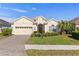 Single-story house with a two-car garage and landscaped lawn at 10788 Trophy Dr, Englewood, FL 34223