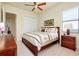 Comfortable bedroom with a queen-size bed, wood furniture and ceiling fan at 20314 Passagio Dr, Venice, FL 34293