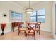 Bright dining room with glass-top table and four chairs, featuring a view to the outdoors at 20314 Passagio Dr, Venice, FL 34293