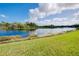 Serene lakefront property with clear water and green grass at 20314 Passagio Dr, Venice, FL 34293