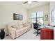 Home office featuring a large window, comfortable sofa, and desk at 20314 Passagio Dr, Venice, FL 34293