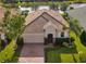 One-story home with tile roof, brick driveway, and landscaped lawn. Water view at 2049 Mesic Hammock Way, Venice, FL 34292