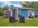 Gray shed with blue doors and a grassy area at 2191 Park Rd, Venice, FL 34293