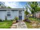 House exterior with gray siding, dark door, and potted plants at 2191 Park Rd, Venice, FL 34293