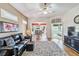 Living room features hardwood floors, black leather couch, and ceiling fan at 2232 Lynx Run, North Port, FL 34286