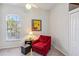 Cozy sitting area with red armchair, ottoman and a large window at 2232 Lynx Run, North Port, FL 34286