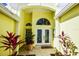 Elegant double front doors with etched glass, flanked by tropical plants at 340 Bermuda Ct # 5, Venice, FL 34293