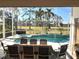 Inviting pool and spa area with screened enclosure and golf course view at 340 Bermuda Ct # 5, Venice, FL 34293