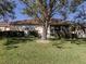 Home's backyard features a large tree and screened patio at 444 Pinewood Lake Dr, Venice, FL 34285